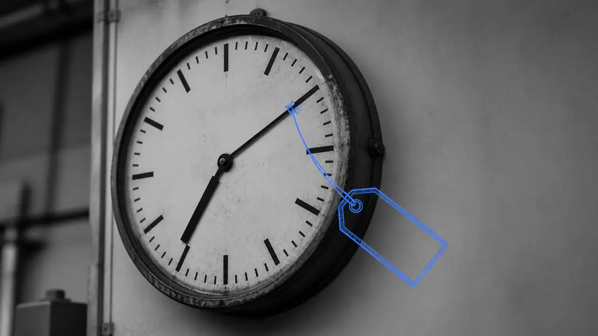 Horloge d'atelier avec une étiquette de prix dessinée à la main accrochée à son aiguille, illustration du coût réel d'une heure de travail dans une TPE.